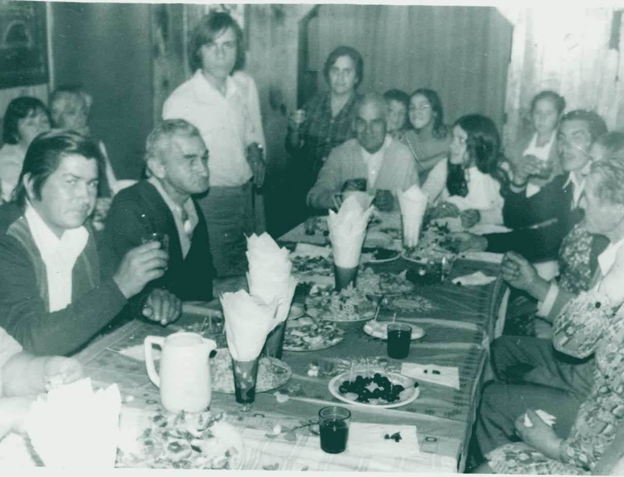 Familia valdiviana reunida alrededor de una mesa larga en una celebración, fotografía de archivo
